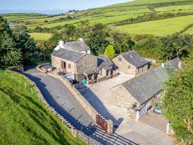 A stone house with a parking area and garden at Elm Lodge in Ulverston