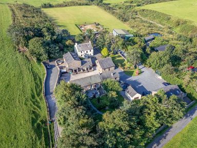 An aerial view of a property with several buildings and a green field at Elm Lodge in Ulverston