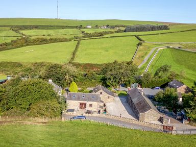 A farmhouse surrounded by fields and trees at Elm Lodge Ulverston