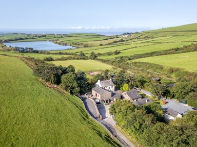 An aerial view of a farmhouse near a lake at Elm Lodge in Ulverston