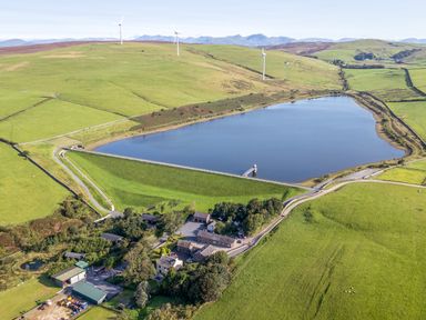 An aerial view of a lake and farm buildings at Elm Lodge in Ulverston