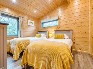 A bedroom with two beds and a window at Elm Lodge in Ulverston