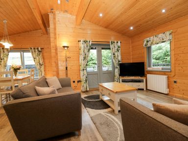 A living room with a sofa and a television at Elm Lodge in Ulverston