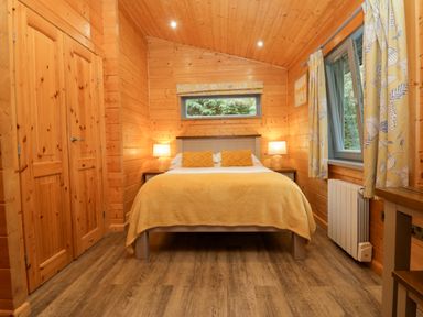 A bedroom with a bed and wardrobe at Elm Lodge in Ulverston