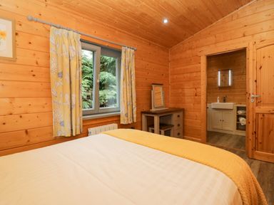 A bedroom with a bed and a bathroom at Elm Lodge in Ulverston