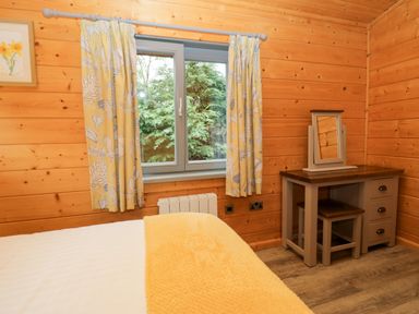 A bedroom with a bed and desk at Elm Lodge in Ulverston