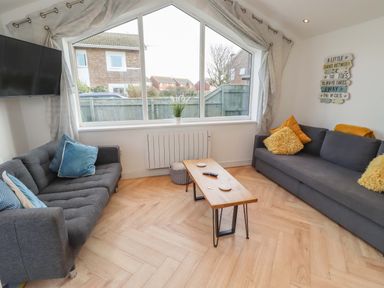 A living room with a sofa and coffee table at Sunrise Cottage in Beadnell