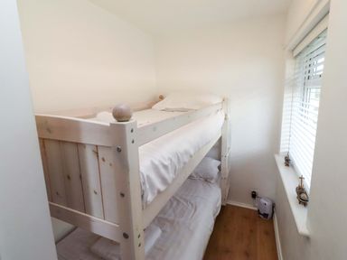 A bedroom with a bunk bed and a window at Sunrise Cottage Beadnell