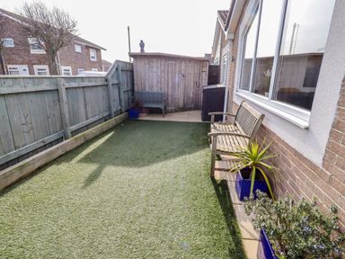 A garden with a bench and plants at Sunrise Cottage Beadnell