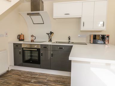 A kitchen with an oven stove microwave kettle utensils and a sink at Squirrels Drey in Little Dunham near Litcham
