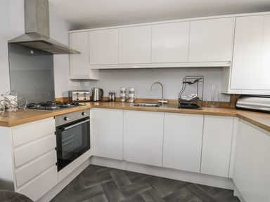 A kitchen with white cabinets wooden countertops a stainless steel oven stove and kettle at Manor Heath Apartment 4 Scarborough