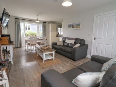 A living room with sofas coffee table dining table and chairs at Flip Flops in The Bay near Filey