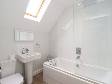 A bathroom with a toilet sink bathtub and skylight window at Flip Flops in The Bay near Filey