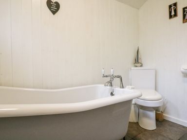 A bathroom with a freestanding bathtub and a toilet at Apple Loft in Lostwithiel