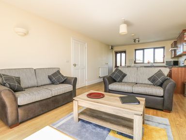 A living room with two sofas a coffee table and a rug at Seashells in Marazion