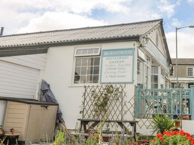 Exterior view of The Boathouse restaurant with a garden and outdoor seating at 1 Dormer Villas in Portscatho