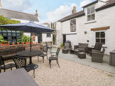A garden with a table and chairs at 1 Dormer Villas Portscatho