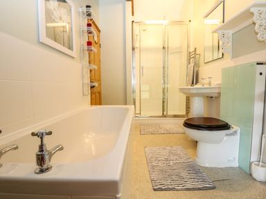 A bathroom with a bathtub toilet sink and a shower enclosure at Chenalls Cottage in Helston