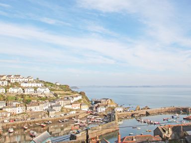 A coastal town with houses on a hillside and boats in a harbor at Mallards in Pentewan