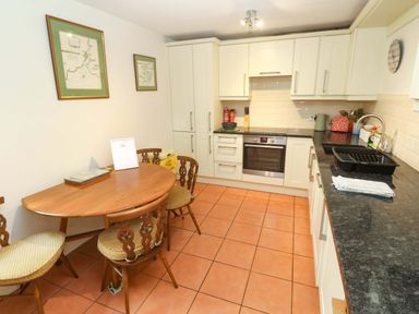 A kitchen with a dining table and chairs at May Cottage in Pentewan