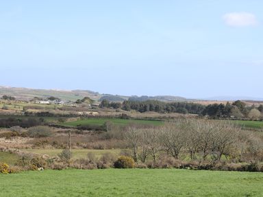 A rural landscape with fields trees and houses in the distance at Boar's House in Penzance