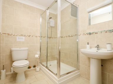 A bathroom with a toilet sink and shower cubicle at Angarrack Farmhouse in Hayle