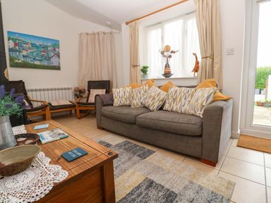 A living room with a sofa and coffee table at Godrevy Cottage in Hayle