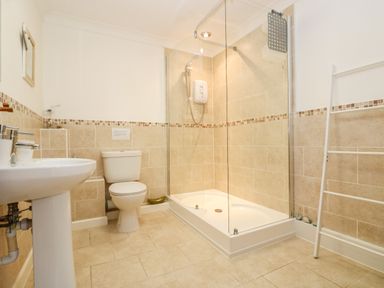 A bathroom with a toilet sink shower and a towel rack at Godrevy Barn in Hayle