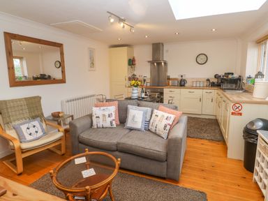 A kitchen with a sofa and coffee table at Godrevy Barn in Hayle