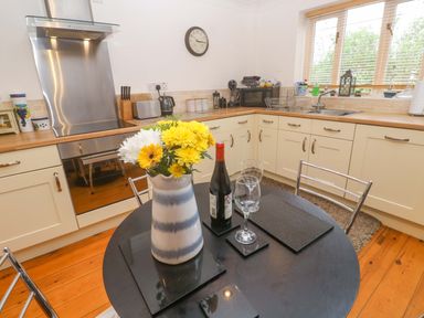 A kitchen with a table set for two at Godrevy Barn Hayle