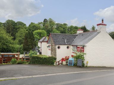 A white building with a slate roof surrounded by trees and a road in front at Little Hamlin Rilla Mill Nr Callington