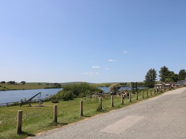 A riverside park with playground equipment and picnic tables along a road at Little Hamlin in Rilla Mill Nr Callington