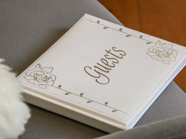 A guest book with floral decorations on a gray surface at Honeysuckle Cottage in Helston