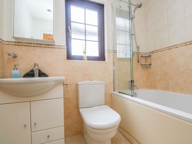 A bathroom with a toilet sink and bathtub with shower at Carne Mill in Manaccan