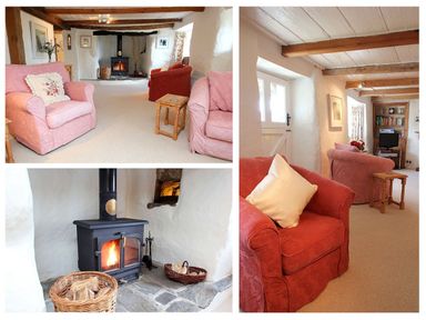 A living room with armchairs a wood burning stove and wooden beams at Rose Cottage in Manaccan