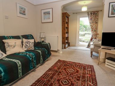 A living room with a sofa and television at Banneth in Helford
