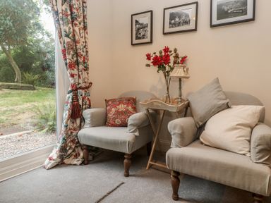 A snug with two armchairs and a small table at Banneth in Helford