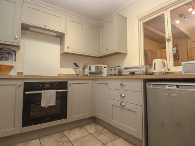 A kitchen with cabinets and appliances at Banneth in Helford