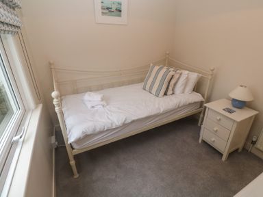 A bedroom with a single bed and a nightstand at Banneth in Helford