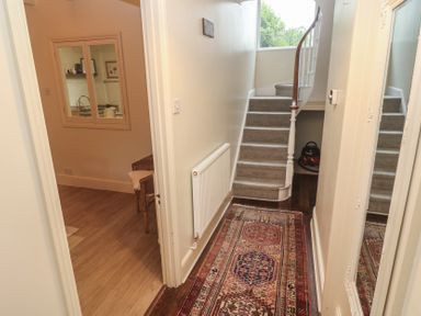 A hallway with staircase and chair at Banneth in Helford