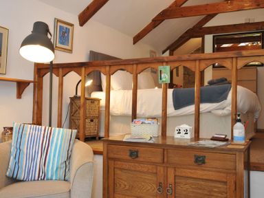 A bedroom with a bed and seating area at Trevenning Chapel Near Port Isaac