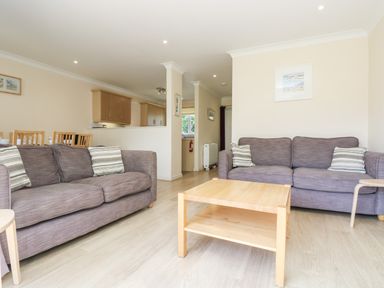 A living room with two sofas a wooden coffee table and a dining area at Trelease in Falmouth