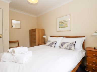 A bedroom with a bed made with white linens and patterned pillows at Trelease in Falmouth
