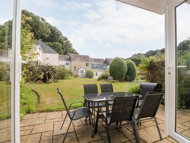 A garden with patio furniture and houses in the background at Trelease in Falmouth