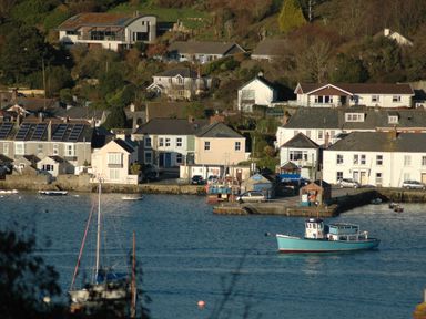 A coastal village with houses, boats in the water, and a small harbor at Seabien in Falmouth