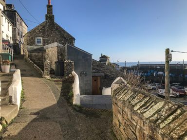 Stone houses and pathway near a harbor with boats and sea at Glanville House in Mevagissey