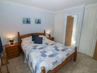 A bedroom with a bed and wardrobe at Glebe House in Bigbury