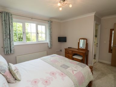 A bedroom with a bed and dresser at Glebe House in Bigbury