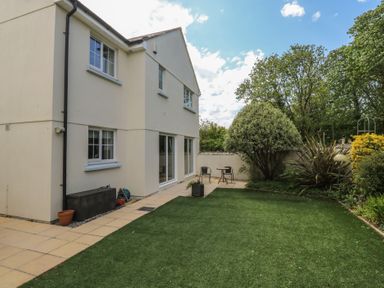 A garden with chairs and a house at Glebe House in Bigbury