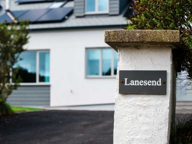 A house with solar panels and a sign labeled Lanesend at Lanesend in St Agnes